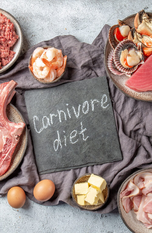 Display of food including meat, beef, chicken, eggs, bacon, butter, and seafood with a carnivore diet sign