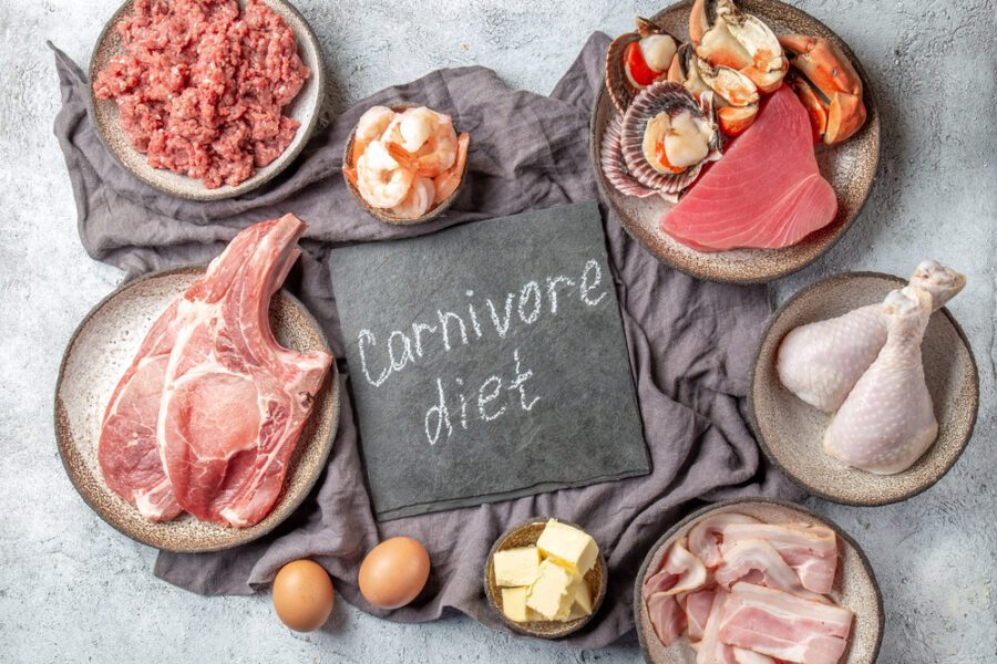 Display of food including meat, beef, chicken, eggs, bacon, butter, and seafood with a carnivore diet sign